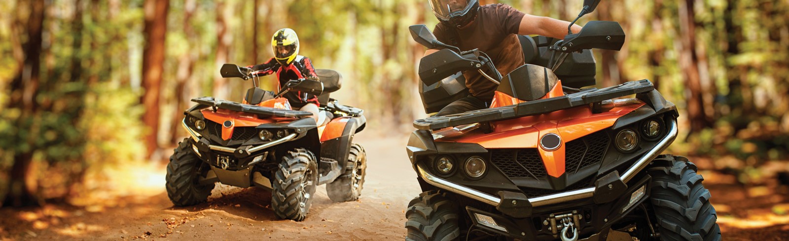 2 orange ATVs in the woods